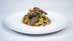Korean Zucchini noodles with beef on a white plate